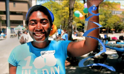 A 100In1Day participant holding a spiral-shaped paper decoration.