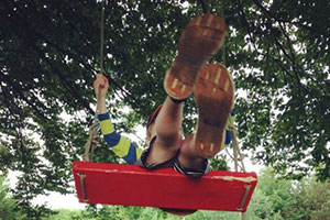 A boy playing on one of the dozen red swings installed across the city of Halifax for The Red Swing Project (photo: Meghan Ruston)
